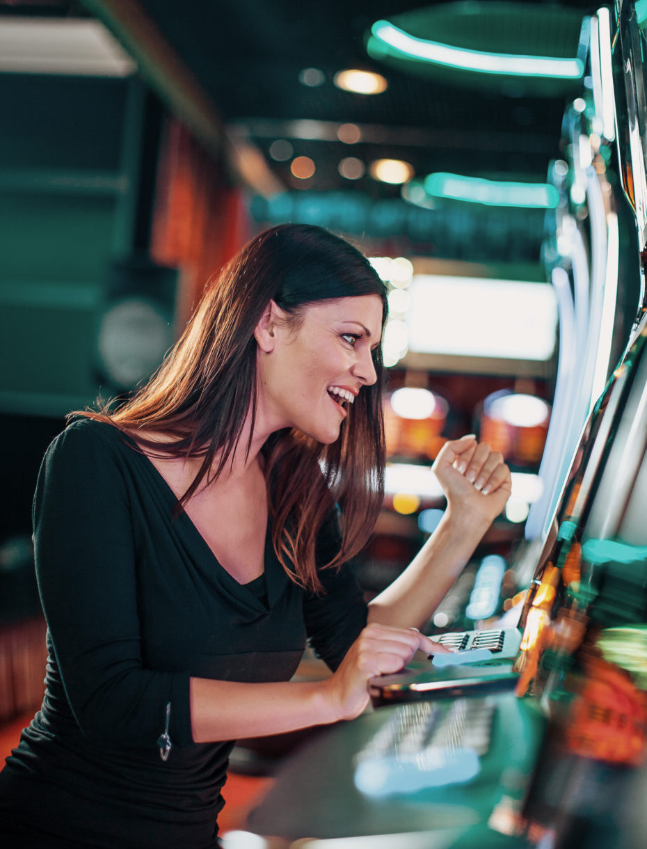 Elegant woman playing on a slot machine