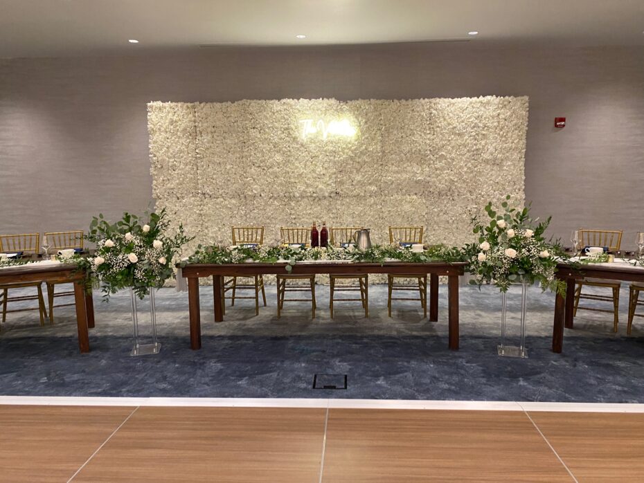 head table with floral backdrop and white flowers