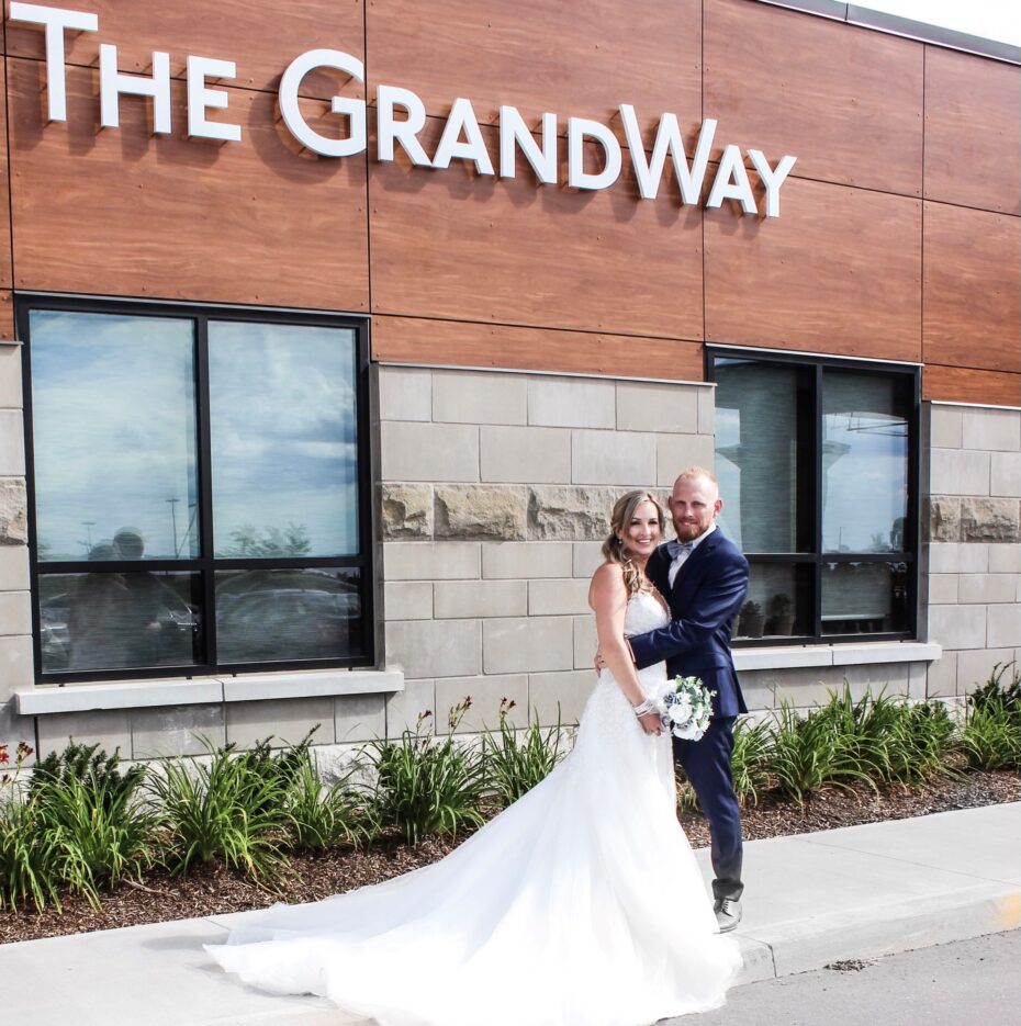 couple stands outside GrandWay sign
