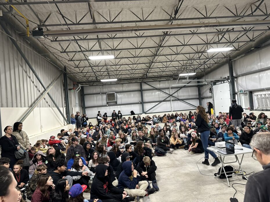 crowd of students in barn with a speaker standing presenting